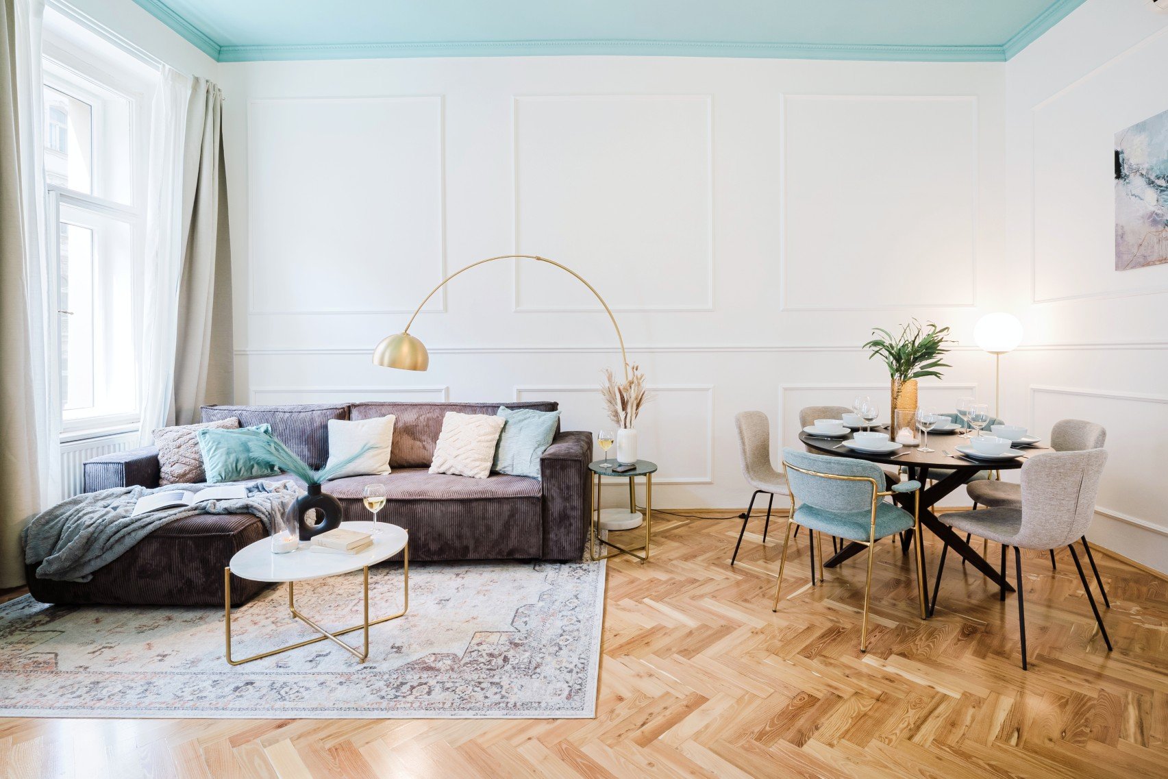 Realizare: tavan colorat, lumină naturală și stratificarea texturilor pentru un aspect aerisit și confortabil.