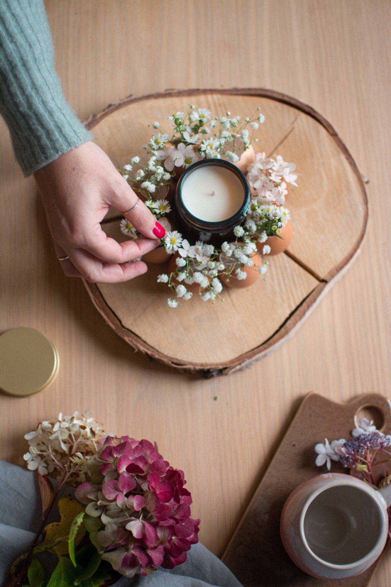 Aranjamentul decorativ din coji de ouă poate fi așezat pe o bucată de lemn.